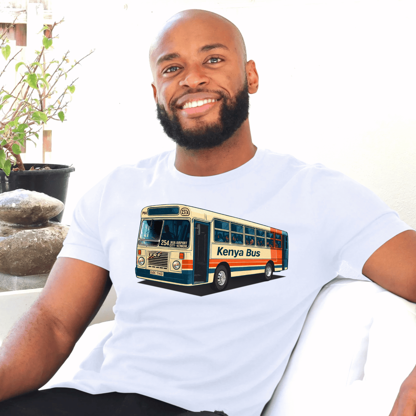 Man wearing a white t-shirt with a Kenya bus made by marto and t-shirts